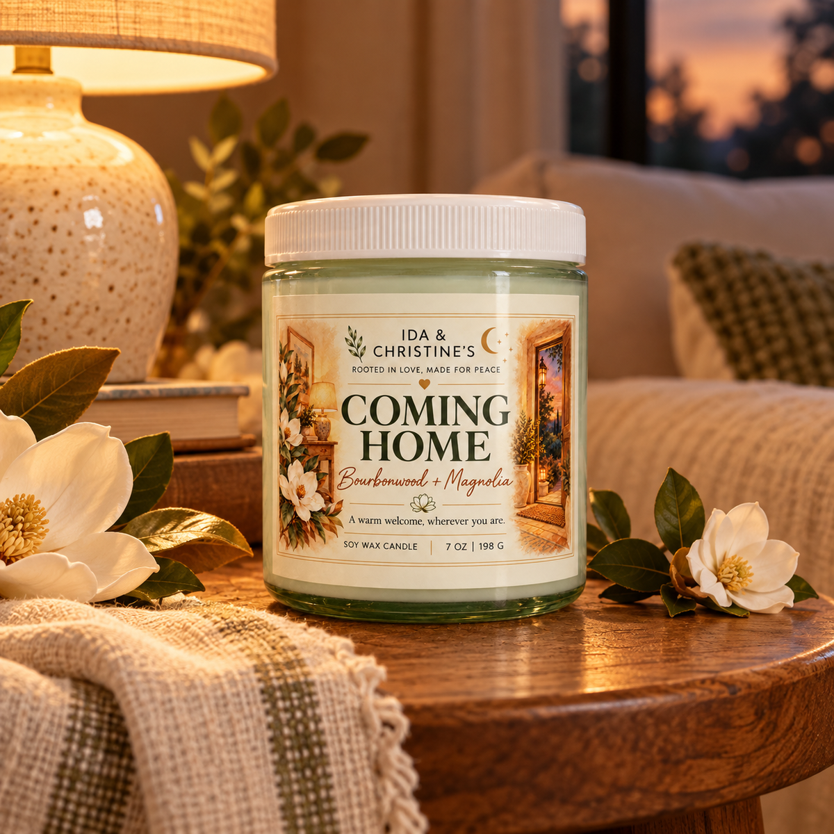 Coming Home 7 oz soy candle in a warmly lit room with magnolia blossoms
