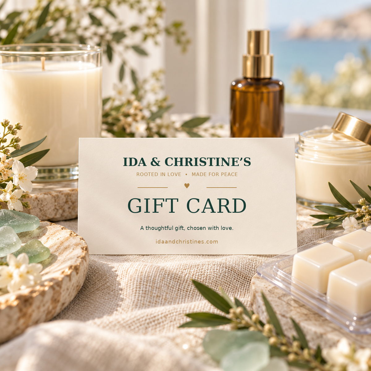 Ida & Christine’s digital gift card surrounded by candle, room spray, body butter, and wax melts